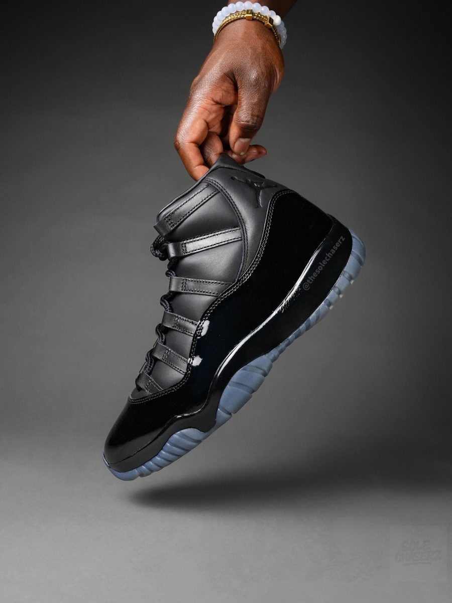 COMME des GARÇONS HOMME PLUS × Air Jordan 11 ブラックを手に持つイメージ
